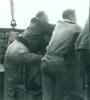 Men leaning on side of a ship